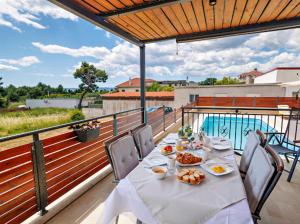 卡什泰拉Villa 3D by the Sea with pool and included breakfast的阳台上摆满食物的桌子