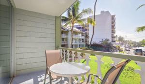 een balkon met een tafel en stoelen en uitzicht op de oceaan bij Kona Islander in Kailua-Kona