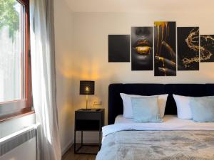 a bedroom with a bed with paintings on the wall at Haus am Strand in Zingst
