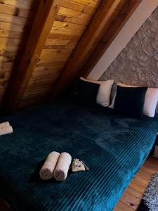 a bed in a attic with two pillows and a wooden ceiling at Cozy Cottage Vlašić in Vlasic