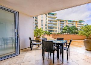 a patio with a table and chairs and a balcony at Honua Kai H237 in Lahaina