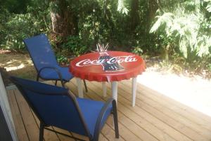 a cocacola table and two chairs on a deck at Nesting Ravens cottage in Nanaimo