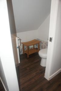 a bathroom with a toilet and a wooden table at Nesting Ravens cottage in Nanaimo +6 photos