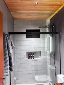 a bathroom with a shower with a toilet and a sink at Cabana Maciambu casa de praia Palhoça SC in Palhoça