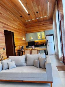 a living room with a couch and a kitchen at Cabana Maciambu casa de praia Palhoça SC in Palhoça