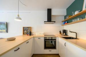 een keuken met witte kasten en een spoelbak bij Strandläufer in Schilksee