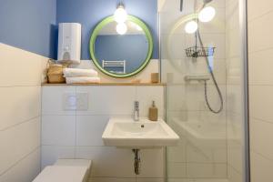 een badkamer met een wastafel en een spiegel en een douche bij Strandläufer in Schilksee