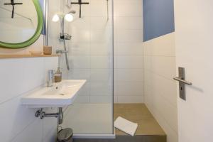 een badkamer met een wastafel en een douche bij Strandläufer in Schilksee +9 foto's