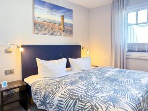 ein Hotelzimmer mit Bett und Blick auf den Strand in der Unterkunft Meerle 3 in Zingst