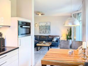 eine Küche und ein Wohnzimmer mit Sofa und Tisch in der Unterkunft Meerle 3 in Zingst
