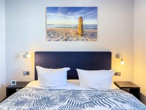 ein Schlafzimmer mit einem Bett, auf dem ein Bild von einem Strand prangt in der Unterkunft Meerle 3 in Zingst + 11 Fotos