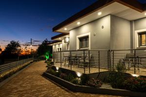 een huis met een balkon in de nacht bij Olea Apartments in Razáta