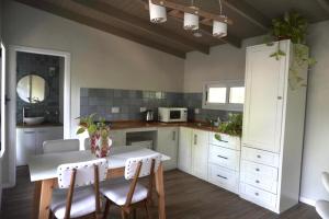 a kitchen with white cabinets and a table and chairs at Blanco Jazmines in Concepción del Uruguay