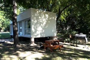 a tiny house with a picnic table and a bench at Blanco Jazmines in Concepción del Uruguay