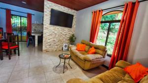 蒙泰韦尔德哥斯达黎加La Macadamia - Monteverde的带沙发、电视和桌子的客厅