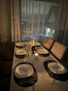 a table with plates and glasses and a bottle of wine at Glamoon Mountain Apartment with Jacuzzi and Sauna, Nowy Targ in Nowy Targ