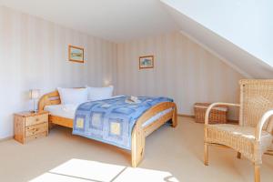 een kleine slaapkamer met een bed en een stoel bij Darßwaldradler in Wieck