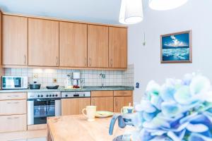 een keuken met houten kasten en een houten tafel bij Darßwaldradler in Wieck