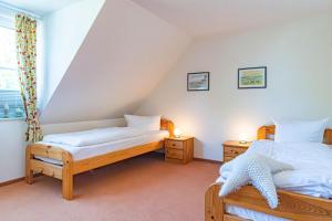 een slaapkamer met twee bedden en twee nachtkastjes bij Darßwaldradler in Wieck