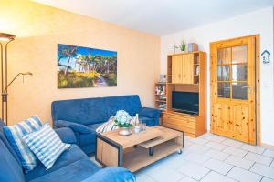 een woonkamer met een blauwe bank en een salontafel bij Darßwaldradler in Wieck