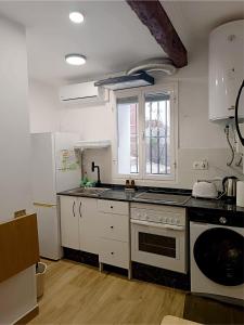 a kitchen with white cabinets and a stove top oven at Apartamento La Cueva in Algarrobo