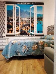 a bedroom with a window with a view of a city at Apartamento La Cueva in Algarrobo