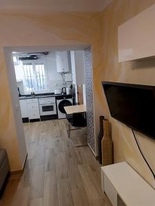 a room with a kitchen and a living room with a flat screen tv at Apartamento La Cueva in Algarrobo +21 photos