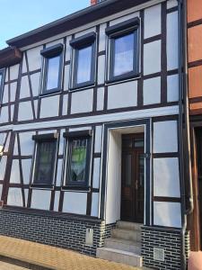 a black and white house with a front door at Gästezimmer Fischer in Ellrich