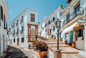 een straat met witte gebouwen en een straatlicht bij La morada de Rosafina in Frigiliana