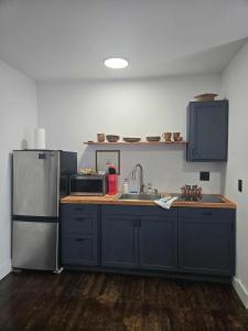 a kitchen with blue cabinets and a stainless steel refrigerator at The Gratiot in Detroit