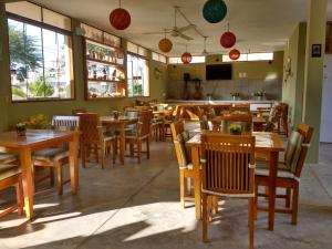 a dining room with wooden tables and chairs at Punta Sal Bungalows in Canoas de Punta Sal