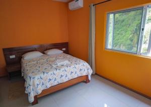 ein Schlafzimmer mit einem Bett und einem Fenster in der Unterkunft Residencial Chez Flávia in Pombas