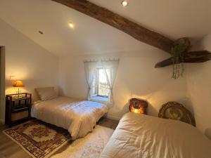 a attic bedroom with two beds and a window at Villa Le Chant du Tilleul in Le Poët-Laval