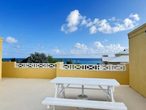 a white picnic table on a balcony with the ocean at 8 Coral Haven in Christ Church