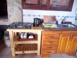 a kitchen counter with a sink and a stove at Entre aromos y lavandas in San Clemente del Tuyú