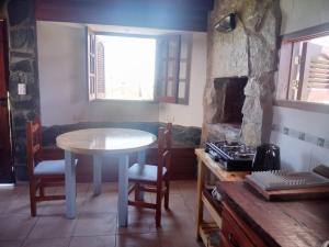 a kitchen with a table and a table and a stove at Entre aromos y lavandas in San Clemente del Tuyú