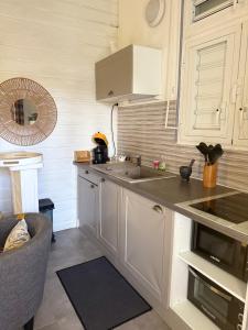 een keuken met witte kasten en een spoelbak bij Les Algues de la Chapelle in Anse-Bertrand +68 foto's