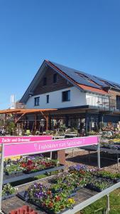 een gebouw met een bloementuin ervoor bij Lemp's Genussgarten in Langenargen