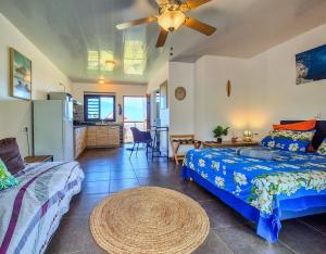 un soggiorno con due letti e una cucina di Studio Tropical - climatisé - vue mer et montagnes - canoes et paddle offerts ! Teahupo'o Lodge Tahiti a Teahupoo Altre 12 foto