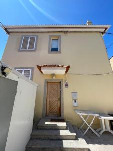 een gebouw met een deur en een trap ervoor bij Casa cidade e piscina in Coimbra
