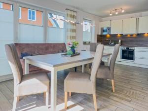 a kitchen with a dining room table and chairs at Kleiner Seehund in Groß Kirr