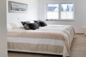 a bedroom with a large bed in a white room at Kleiner Seehund in Groß Kirr