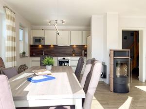 a kitchen and dining room with a table and chairs at Kleiner Seehund in Groß Kirr +18 photos