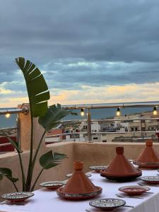 a table with plates and vases on a balcony at Shams House in Imsouane