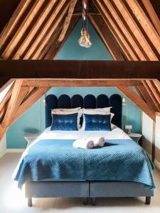a bedroom with a blue bed with a stuffed animal laying on it at Number 9 holiday apartments in Middelburg