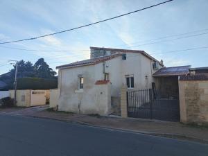 een klein wit huis aan de kant van een straat bij Le loudunais in Loudun