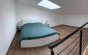 een slaapkamer met een bed met een groene deken bij Le loudunais in Loudun