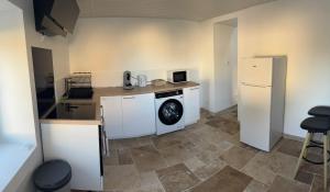 een keuken met een wasmachine en een koelkast bij Le loudunais in Loudun