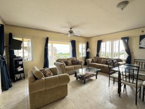 a living room with two couches and a table at 8 Coral Haven in Christ Church