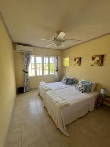 a bedroom with two beds and a ceiling fan at 8 Coral Haven in Christ Church +19 photos